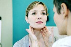 'dentist checking woman for oral cancer'