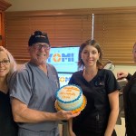 Staff holding a cake