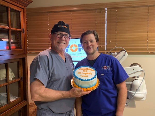 Two staff members holding cake