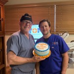 Two staff members holding cake